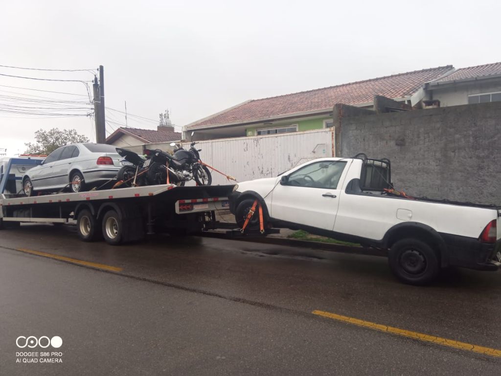 Motocicleta e carro transportados na plataforma da Gama Auto Socorro