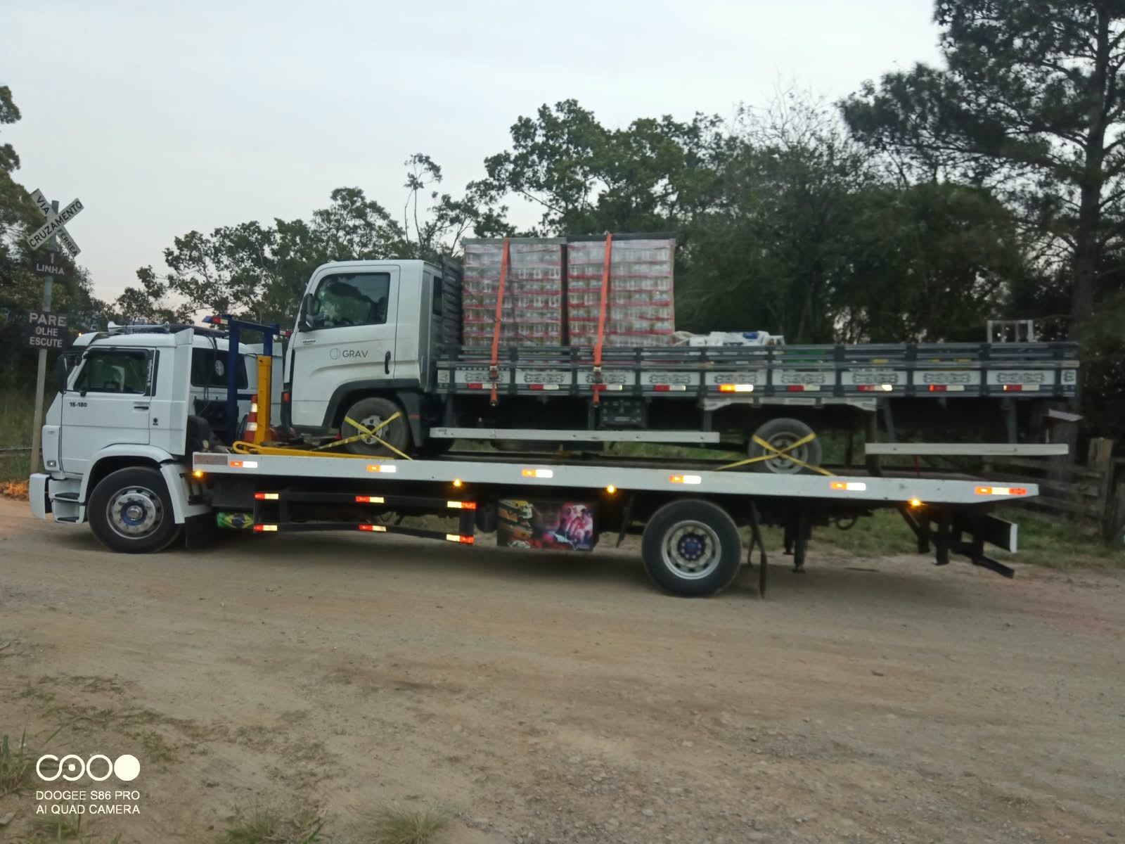 Retroescavadeira John Deere na plataforma do caminhão da Gama Auto Socorro